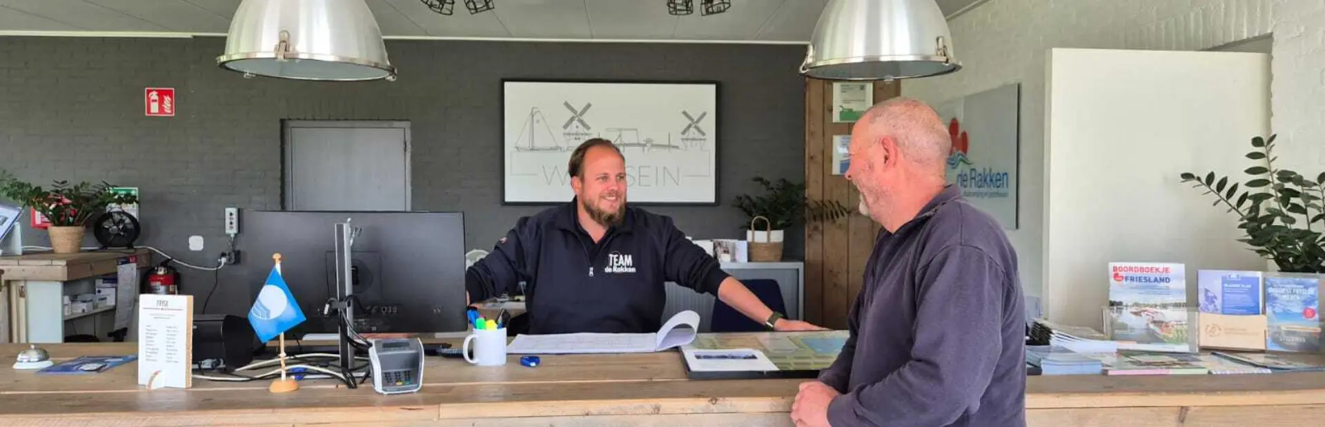 Axl achter de balie van de receptie